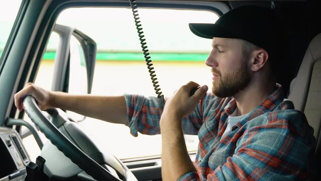 Trucker Preparing For Trip. Caucasian Men Talking on CB Radio. Truck Driver Job. Right Hand Drive Car