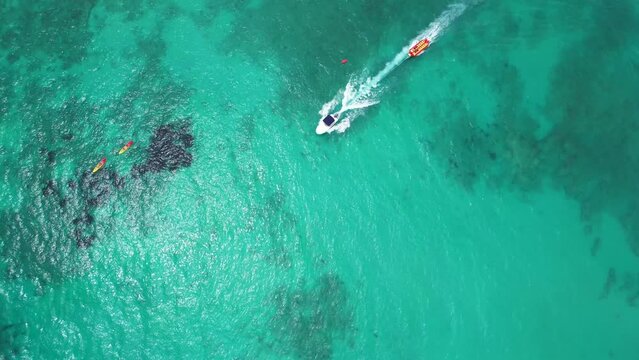 Aerial view of a Banana boat ride in Sa Coma beach in Mallorca, Spain on a summer day