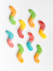 Multi-colored marmalade candies in sugar on a white background, top view.