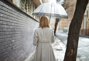 Not every day can be sunny. Rearview shot of a woman walking down a street in the rain and holding an umbrella.