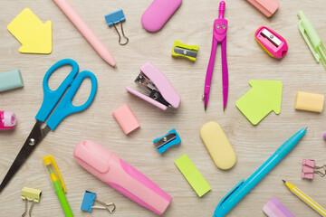 Flat lay with colorful school stationery on wooden backgroung, top view