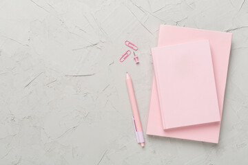 Notebooks with stationery on concrete background, top view