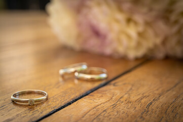 colorful mug of coffee on wooden surface with engagement rings and ring, concept of engagement,...