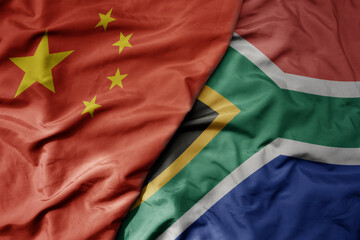 big waving national colorful flag of china and national flag of south africa .