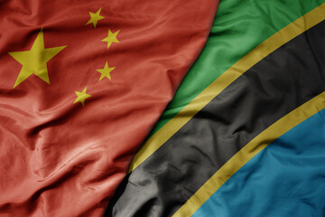 big waving national colorful flag of china and national flag of tanzania .