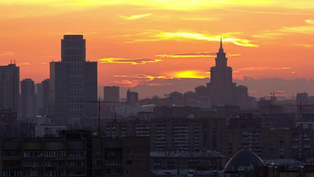 Moscow. Stalin skyscraper on the background of a large the sunset sun timelapse, Russia. Orange sky. Close up view
