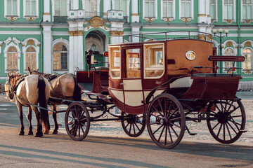 A carriage drawn by two nags is waiting for customers. Walking around the city on a stagecoach.
