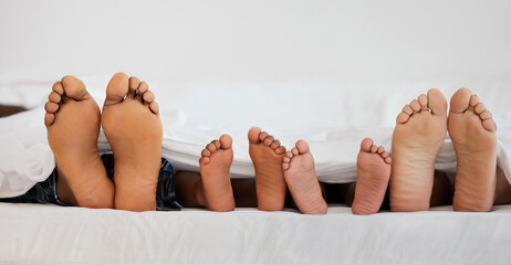 Love, bed and closeup of family feet relaxing, laying and bonding in the bedroom with a blanket....