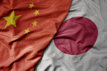 big waving national colorful flag of china and national flag of japan .