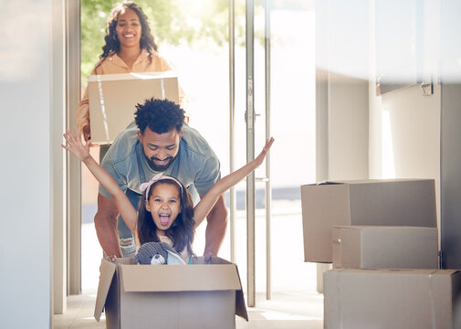 Happy family, boxes and child playing in new home with smile, excitement and mortgage on property investment. Man, woman and girl in box in house, moving and investing in real estate, love and future