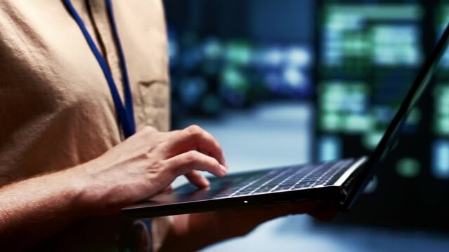 Close up shot of technician writing server farm disaster recovery plan on laptop to provide rapid restoration of service, limiting disruption and minimizing interruptions to normal operations