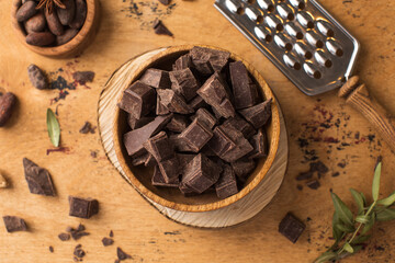 Cubes of dark artisan chocolate in a wooden bowl. Bitter chocolate
