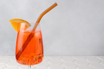 Aperol spritz cold summer cocktail with aperitif, prosecco, ice and slice of orange in a glass on...
