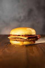 Hamburger with cheese and bacon on a wooden table