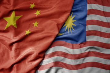 big waving national colorful flag of china and national flag of malaysia .