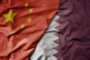 big waving national colorful flag of china and national flag of qatar .