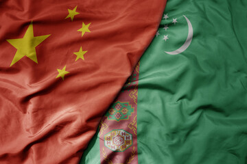 big waving national colorful flag of china and national flag of turkmenistan .