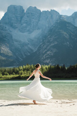 Fototapeta na wymiar Stunning female model in her wedding dress at Lago di Landro
