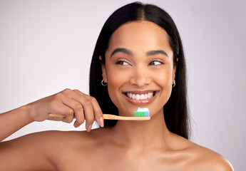 Happy woman, toothbrush and teeth for dental, cleaning or hygiene against a grey studio background. Face of female person with bamboo tooth brush for clean oral, mouth and gum healthcare or wellness