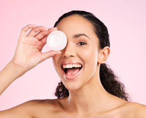 Face, skincare and excited woman with cream container in studio isolated on a pink background....