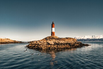 the lighthouse of Les Éclaireurs in ushuaia, tierra del fuego, end of the world, surrounded by a blue ocean in the beagle channel and a beautiful sky