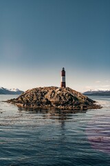 the lighthouse of Les Éclaireurs in ushuaia, tierra del fuego, end of the world, surrounded by a blue ocean in the beagle channel and a beautiful sky
