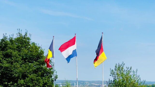 Flags of Belgium, Netherlands and Germany Waving in the Wind on Flagpoles