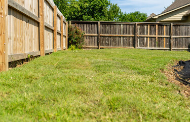 Landscaping Company Tending to A Front Lawn, Flower Bed Cutting Grass, Blowing Debris, and A Retaining Wall
