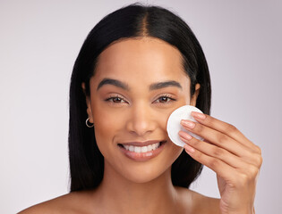 Happy woman, portrait and cotton pad in skincare or makeup removal against a grey studio...
