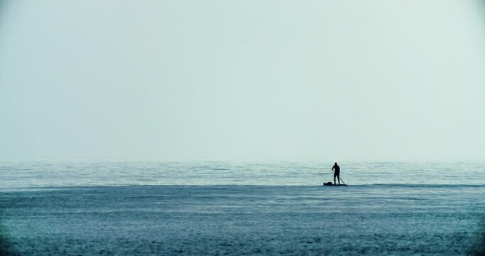 Active sports on the water men's silhouette sabi in the sea. Surfing on the ocean alone with nature. High quality 4k footage