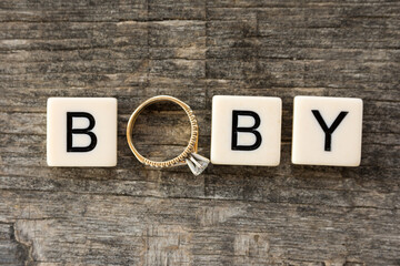 Baby writen with letters and wedding ring