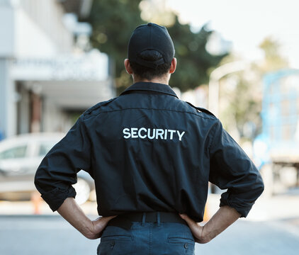 Man, back and security guard in city for safety protection, law enforcement or outdoor emergency. Rear view of male person, police or officer standing ready for crime control to protect and serve