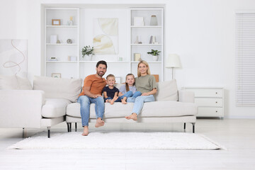 Portrait of happy family with children on sofa at home