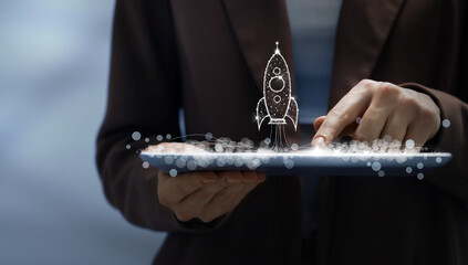 Business startup concept. Woman using tablet computer, closeup. Illustration of launching rocket with smoke over device
