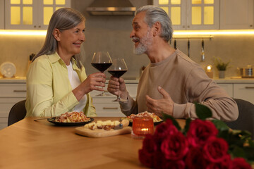 Affectionate senior couple having romantic dinner at home