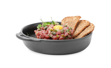 Tasty beef steak tartare served with yolk, capers and sliced bread isolated on white