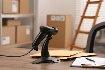 Black modern barcode scanner on wooden table in office. Online store