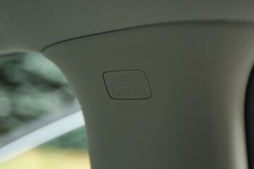 Safety airbag sign on center pillar panel in car, closeup