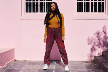 She has style and a whole lotta attitude. Shot of a beautiful young woman posing against a pink...
