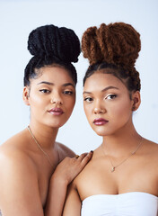 Theyre both ravishing beauties. Studio shot of two beautiful young women posing against a grey...