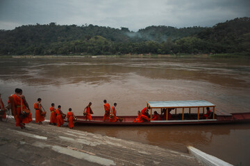 luang prabang lao - july19,2023 : monk and domestic boat in mekong river luangprabang world heritage site of unesco in northern of lao