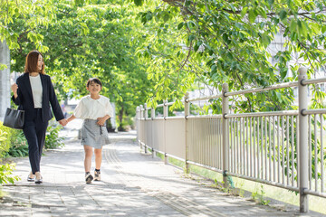 Fototapeta na wymiar 歩道を歩く親子　Parent and child walking on the sidewalk 