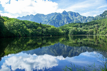 Fototapeta premium 鏡池 長野市戸隠｜聳え立つ戸隠連峰が映り込む湖面の神秘さに言葉を失います 