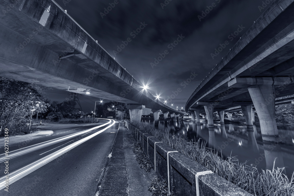 Wall mural Underside of an elevated road across river at night