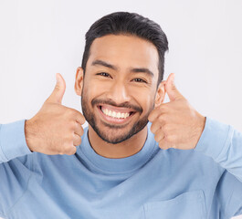 Thumbs up, portrait and asian man happy in studio with hand, sign and thank you on grey background. Smile, face and Japanese male with finger emoji for yes, vote or positive review, feedback or agree