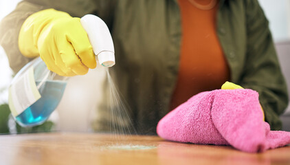 Woman, hands and spray on table with cloth for hygiene, bacteria or germ removal at home. Closeup of female person, housekeeper or maid wiping furniture in domestic service or disinfection on surface