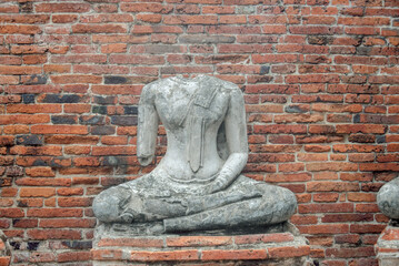 Ancient broken Buddha statues and old brick walls