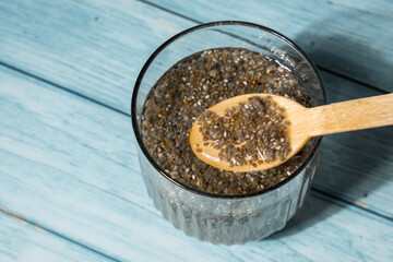 Preparing superfood water drink rich in Omega 3 fatty acids. Pouring coconut water. Adding soaked chia seeds and lemon detox Breakfast. Clean eating, weight loss, dieting food concept Vegetarian