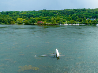 Small capsized sail boat on lake after an afternoon summer storm.