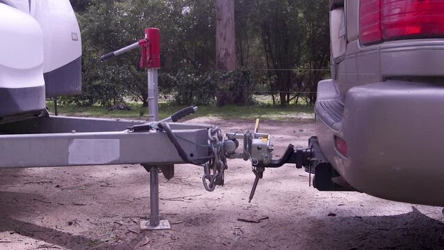 Reversing a car into a caravan or RV trailer hitch then lowering the jockey wheel.